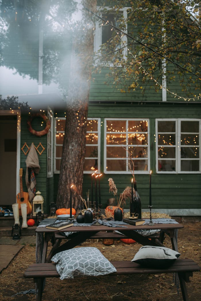 project-03-b Rustic outdoor autumn decor with pumpkins and fairy lights creating a cozy atmosphere.