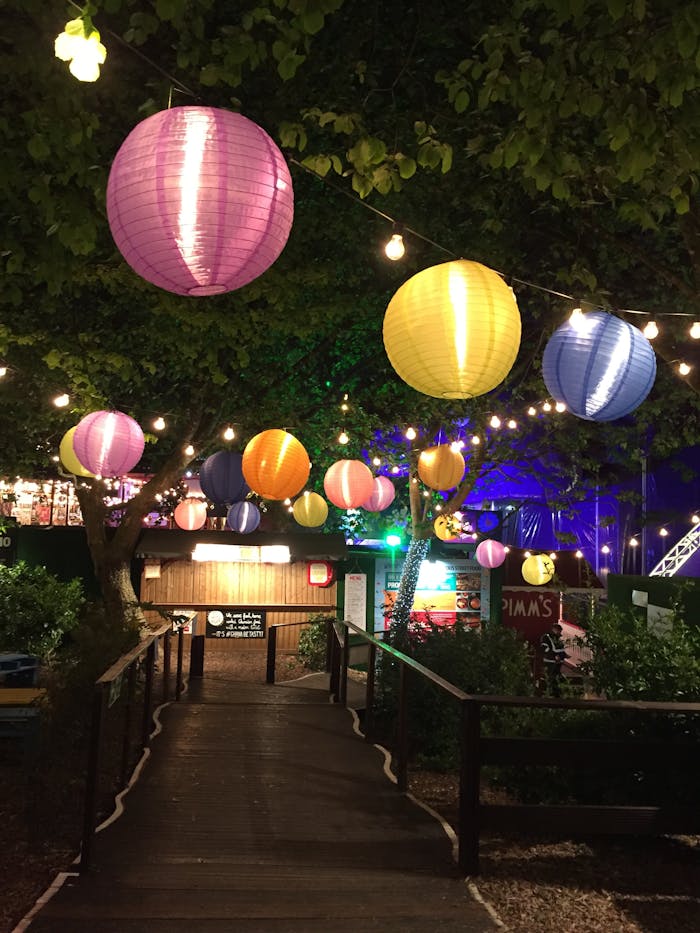 project-03-a Vibrant paper lanterns hanging over a garden path during a festive night celebration outdoors.